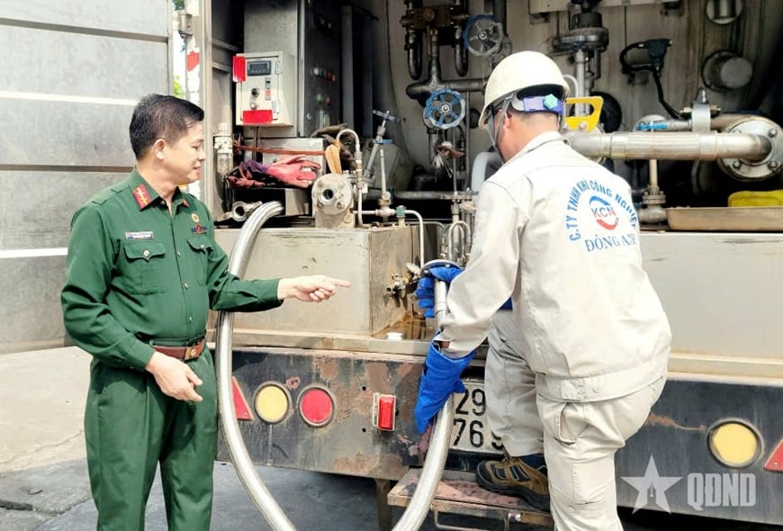 Đảng viên, cựu chiến binh Nguyễn Văn Thuyết, Giám đốc Công ty TNHH Khí công nghiệp Đông Anh hướng dẫn người lao động quy trình nạp các loại khí công nghiệp. Ảnh: QĐND